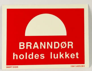 Etterlysende brannskilt - branndør holdes lukket